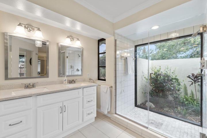 Owners ensuite bathroom featuring dual sinks, garden tub and walk-in showers with courtyard windows, and walk-in closet.