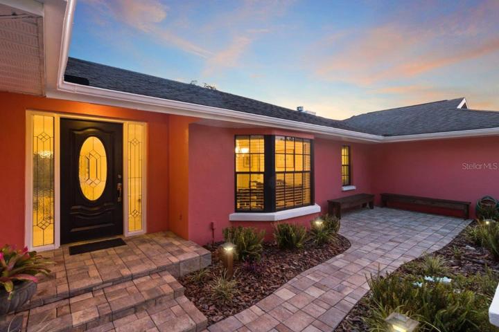 Front Elevation featuring an extended front patio, custom landscape lighting, all on a spacious 1 acre lot