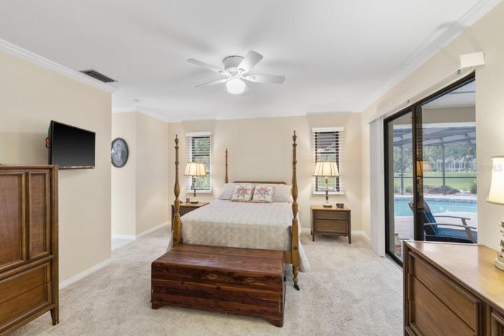 Owners suite featuring newer carpet flooring, pocket sliding glass door to the lanai, and ensuite bathroom.