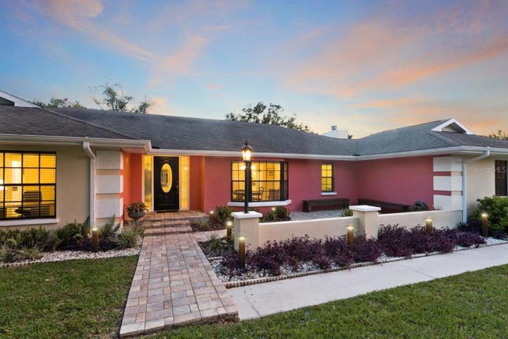 Front Elevation featuring an extended front patio, custom landscape lighting, all on a spacious 1 acre lot