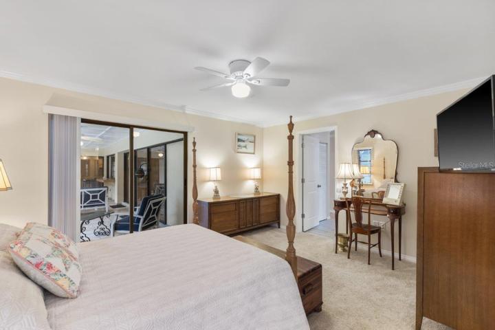 Owners suite featuring newer carpet flooring, pocket sliding glass door to the lanai, and ensuite bathroom.