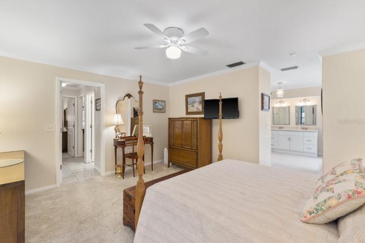 Owners suite featuring newer carpet flooring, pocket sliding glass door to the lanai, and ensuite bathroom.