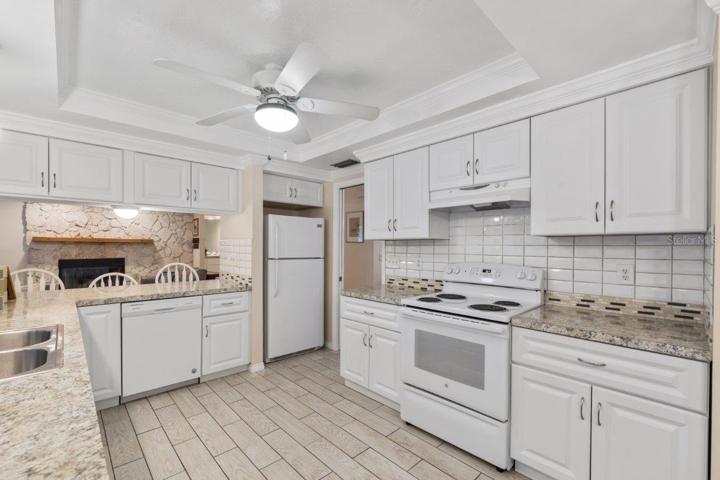 Recently remodeled gourmet kitchen with a spacious breakfast bar with a pass through window, custom eat-in kitchen space, and tray ceilings.