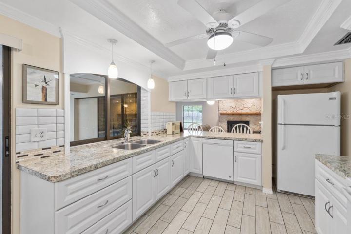 Recently remodeled gourmet kitchen with a spacious breakfast bar with a pass through window, custom eat-in kitchen space, and tray ceilings.