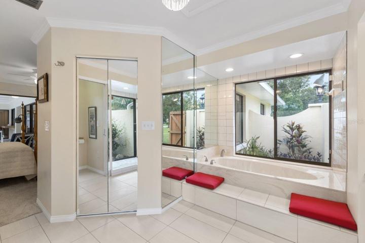 Owners ensuite bathroom featuring dual sinks, garden tub and walk-in showers with courtyard windows, and walk-in closet.