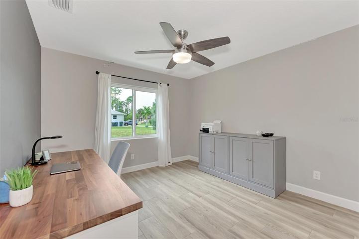 Bedroom 3 is being used as an office with remote ceiling fan.