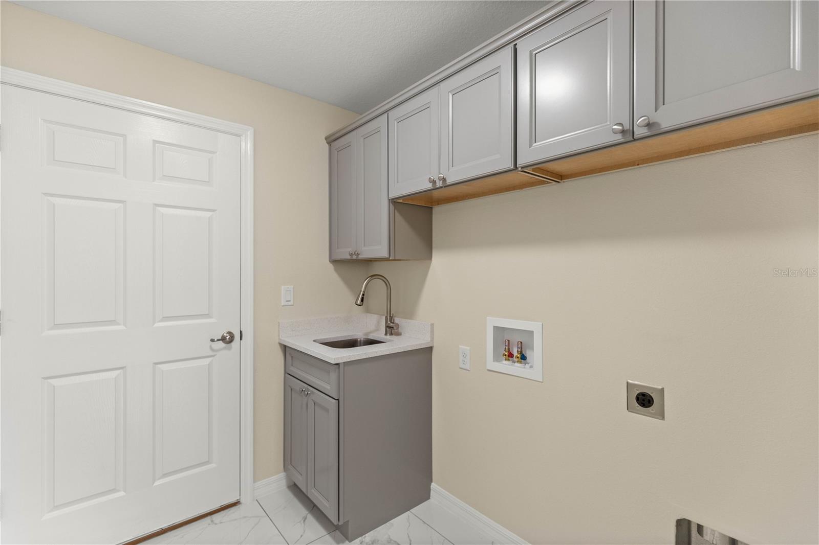 Laundry room with sink and cabinets