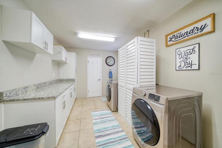 Large laundry room with utility sink and half bathroom.