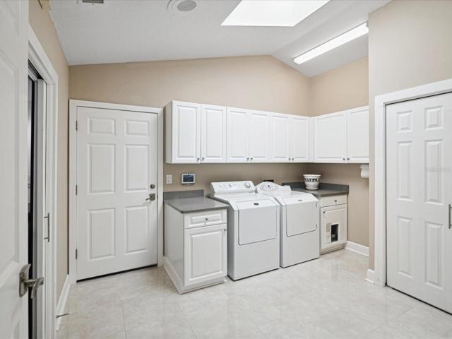 Huge Laundry Room with quartz, cabinets and storage to the right, to the left is bonus/flex room