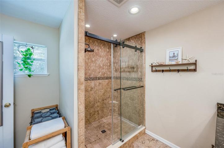 Remodeled primary bathroom with oversize shower and rain shower head