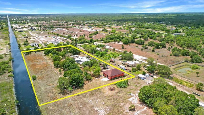 ariel rear view over NE corner ownership extends halfway across canal showing additional acreage purchasable