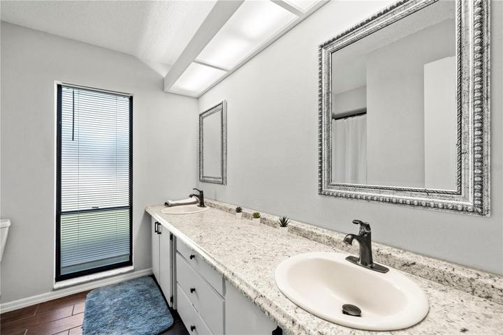 Primary bathroom with dual sinks and a tub/shower combo