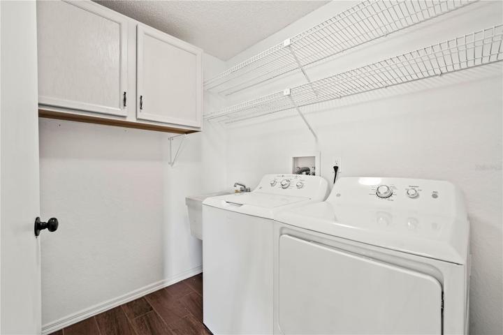 Laundry room with storage and a utility sink