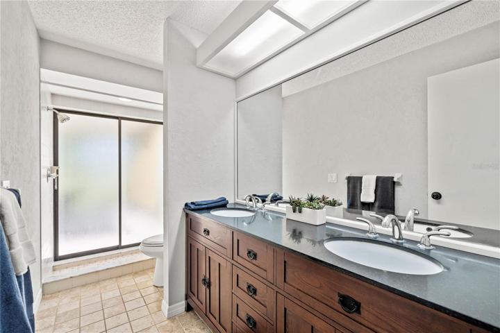 Dual sinks and a tiled walk-in shower