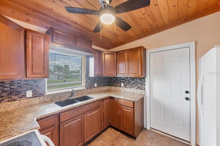 KITCHEN - WOOD CABINETS, GRANTIE COUNTERS - DOOR EXITS TO SIDE YARD