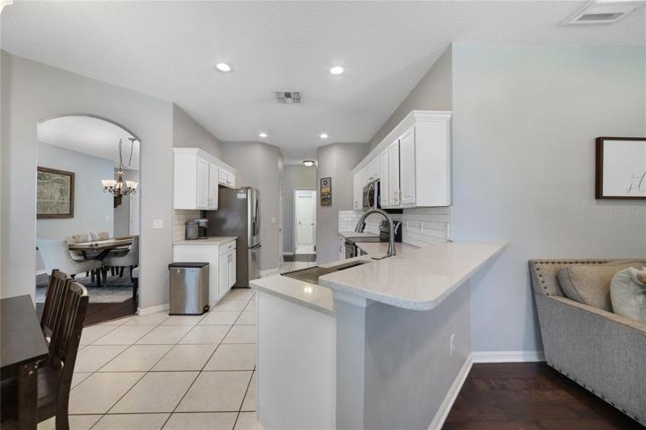 The kitchen is perfectly situated for an easy flow from all rooms and has been thoughtfully updated with QUARTZ COUNTERTOPS, stainless steel appliances, SUBWAY TILE BACKSPLASH, pantry for ample storage and breakfast bar and dinette seating for casual dining!