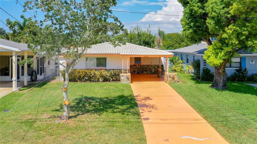 front view covered car port and space on the driveway for multiple cars