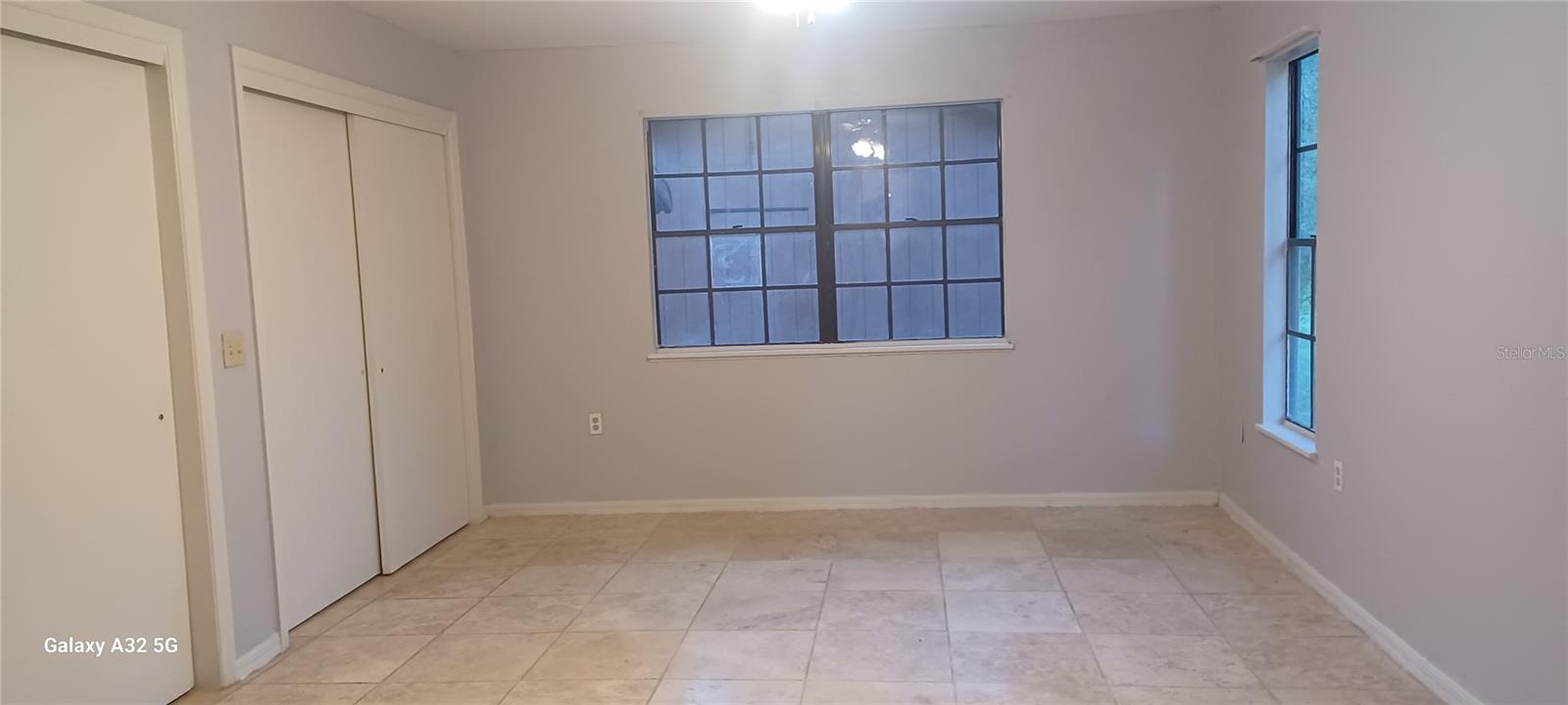 master bedroom with travertine floor and 2 closets