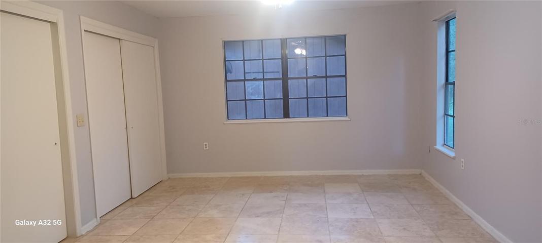 master bedroom with travertine floor and 2 closets