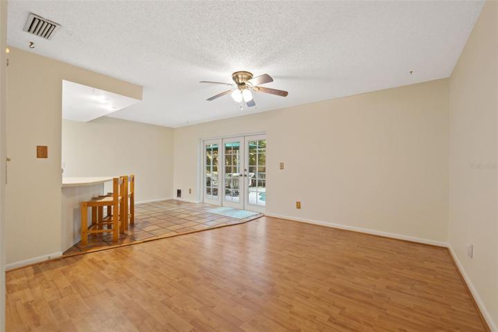 Large living room with access to the kitchen and backyard through beautiful French doors