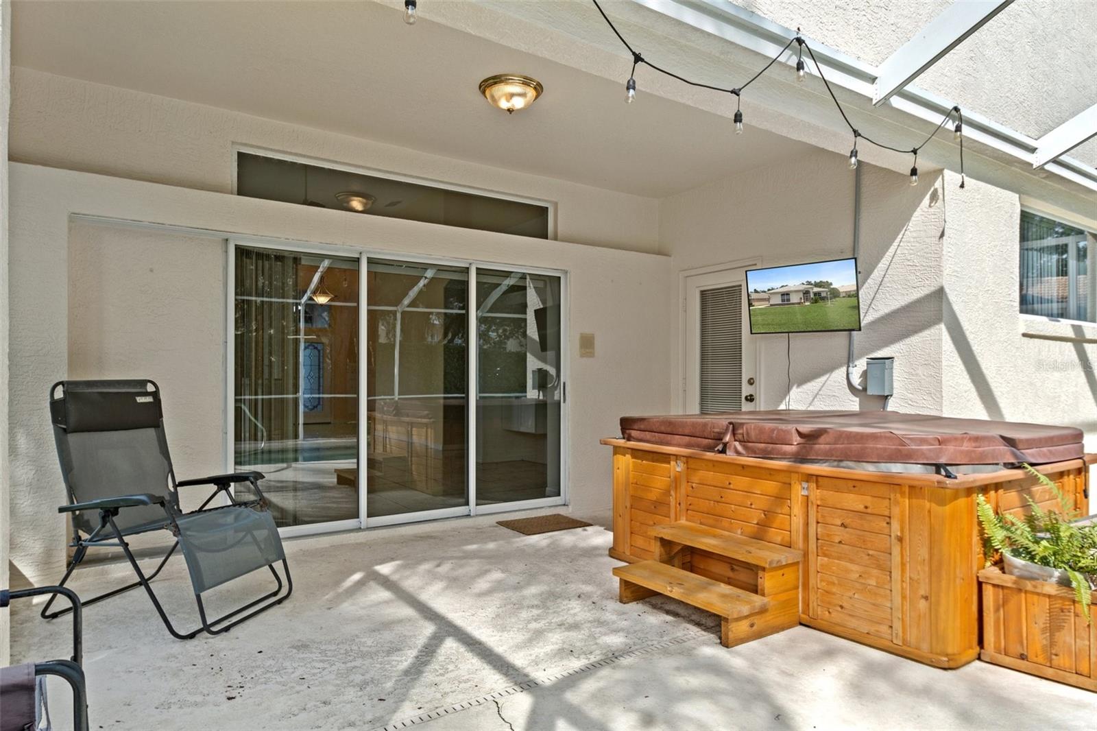 The lanai features pocketing sliding doors and a door that leads to the master bedroom. The newer TV and hot tub are also included!