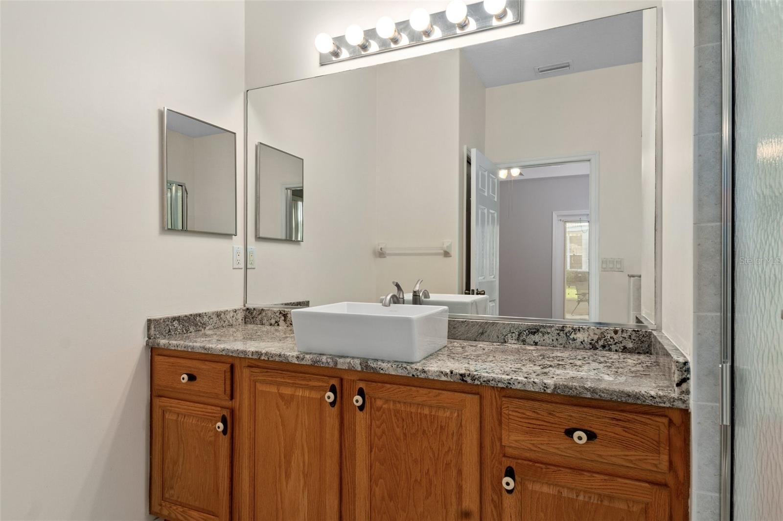 Newer granite countertop, sink and fixtures in master bath. The extended vanity provides additional storage.