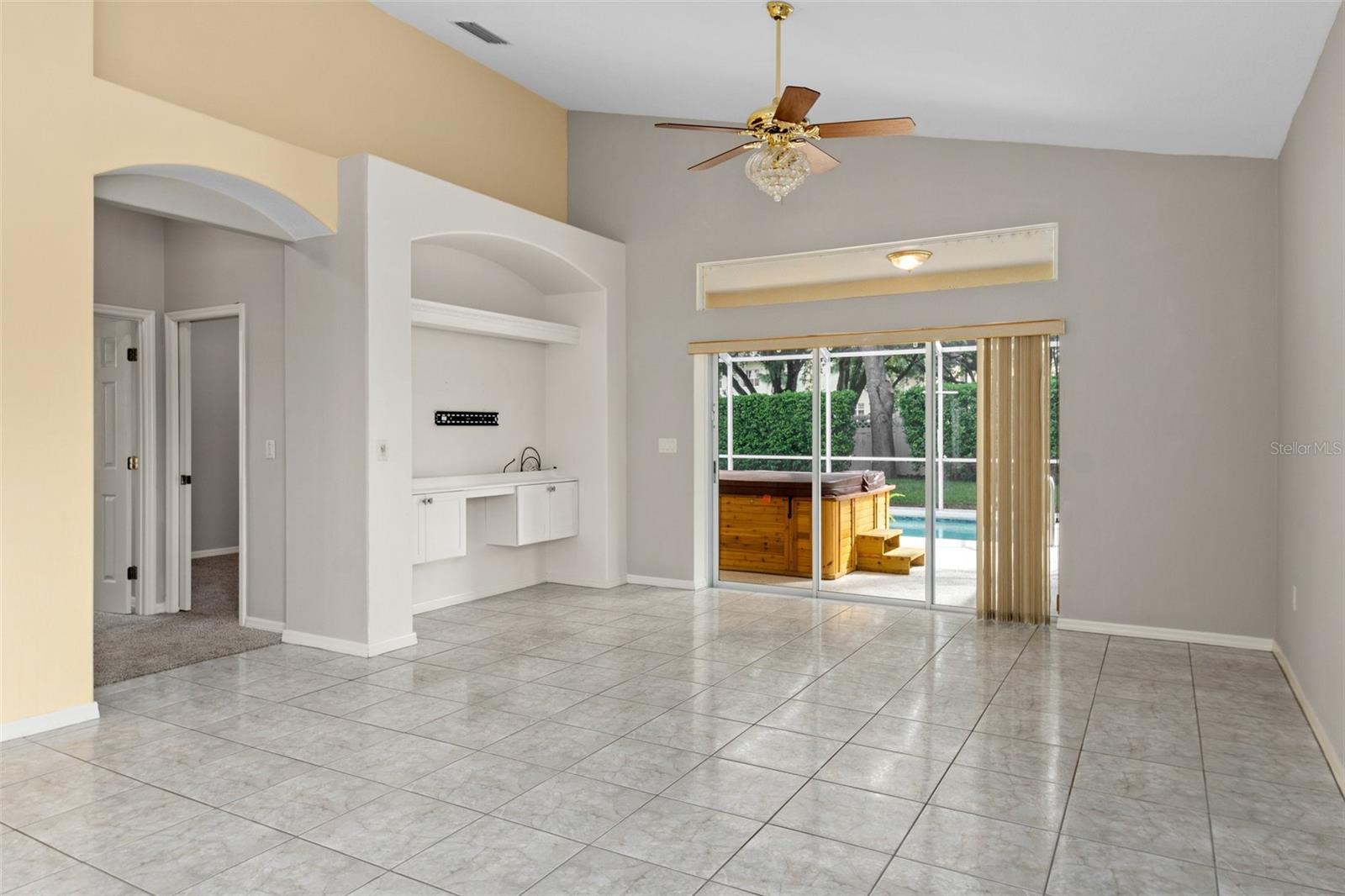 View from dining area looking into living area. The seller recently added the built ins to the entertainment niche. opening to the left leads to master bedroom and center guest bedroom/office.
