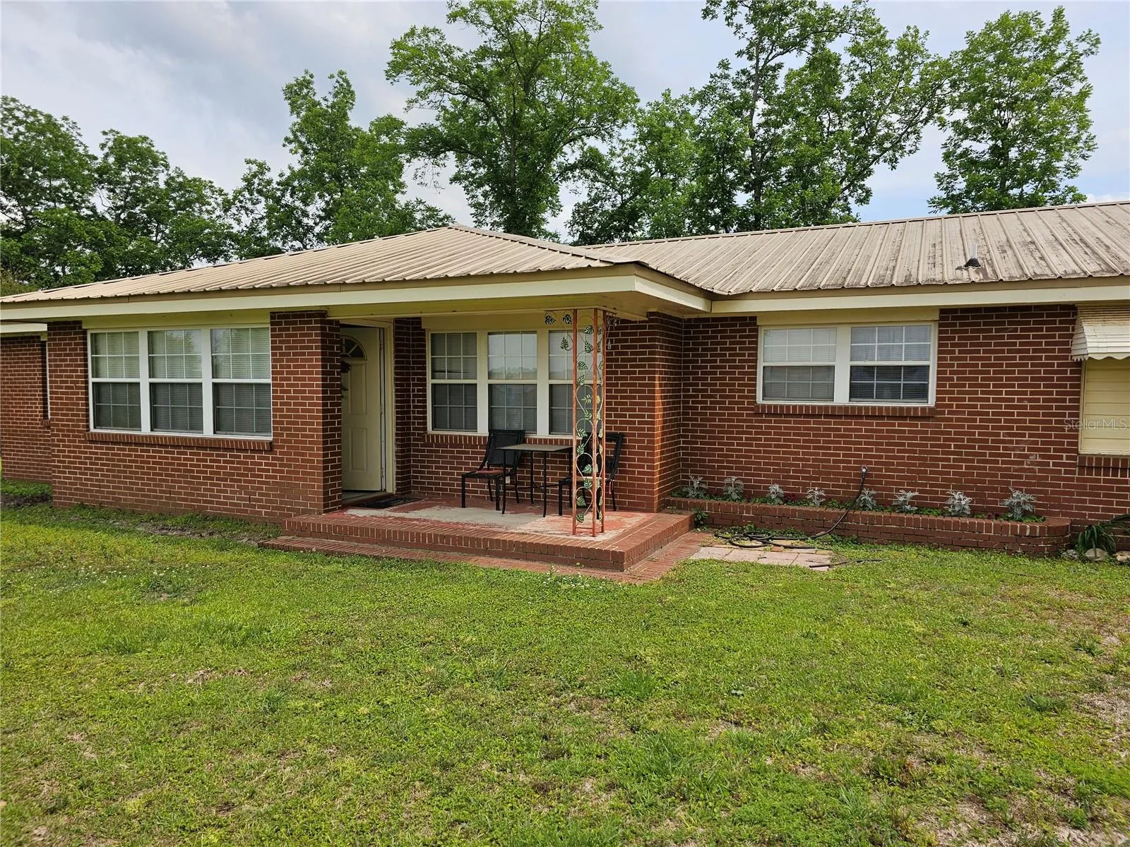 3 bedroom 2 bath ranch style brick home with a metal roof.