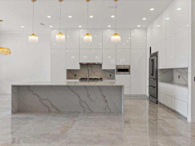 Every detail was considered when remodeling the stunning kitchen, from the fresh modern custom cabinetry, PROFESSIONAL GRADE APPLIANCES, 12’ island with bar seating and the custom countertops and backsplash!
