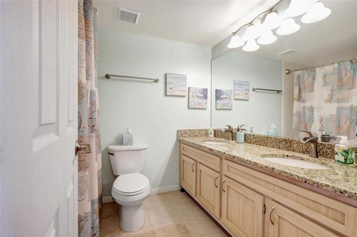The primary bathroom boasts dual sinks, making morning routines a breeze for you and your partner. The bathroom features a generously-sized mirror, perfect for getting ready in style. And of course the cabinets, for your personal storage.