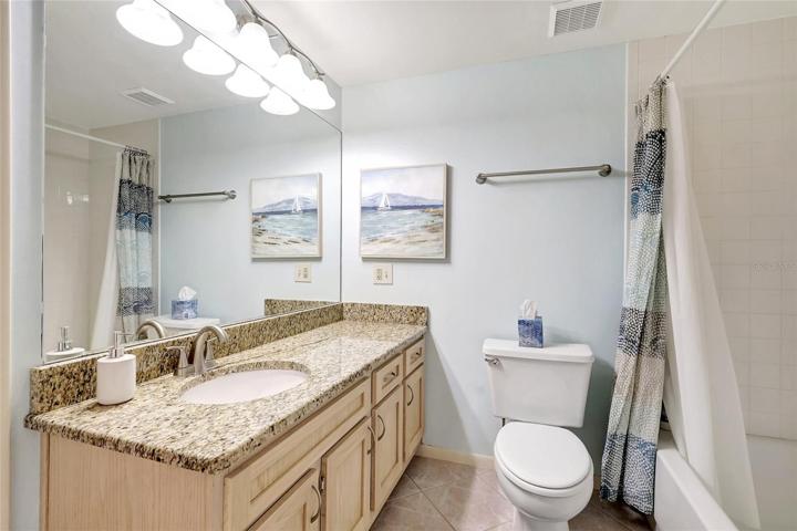 One of the bathrooms boasts a generously-sized mirror, perfect for getting ready in the morning or freshening up throughout the day. It includes a sink for your convenience.