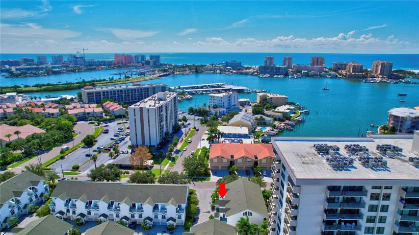 Enchanting aerial view of a townhome enveloped by serene waters.