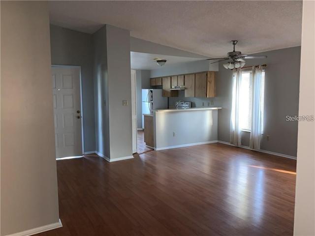 View of entrance, living room, kitchen from walkway.