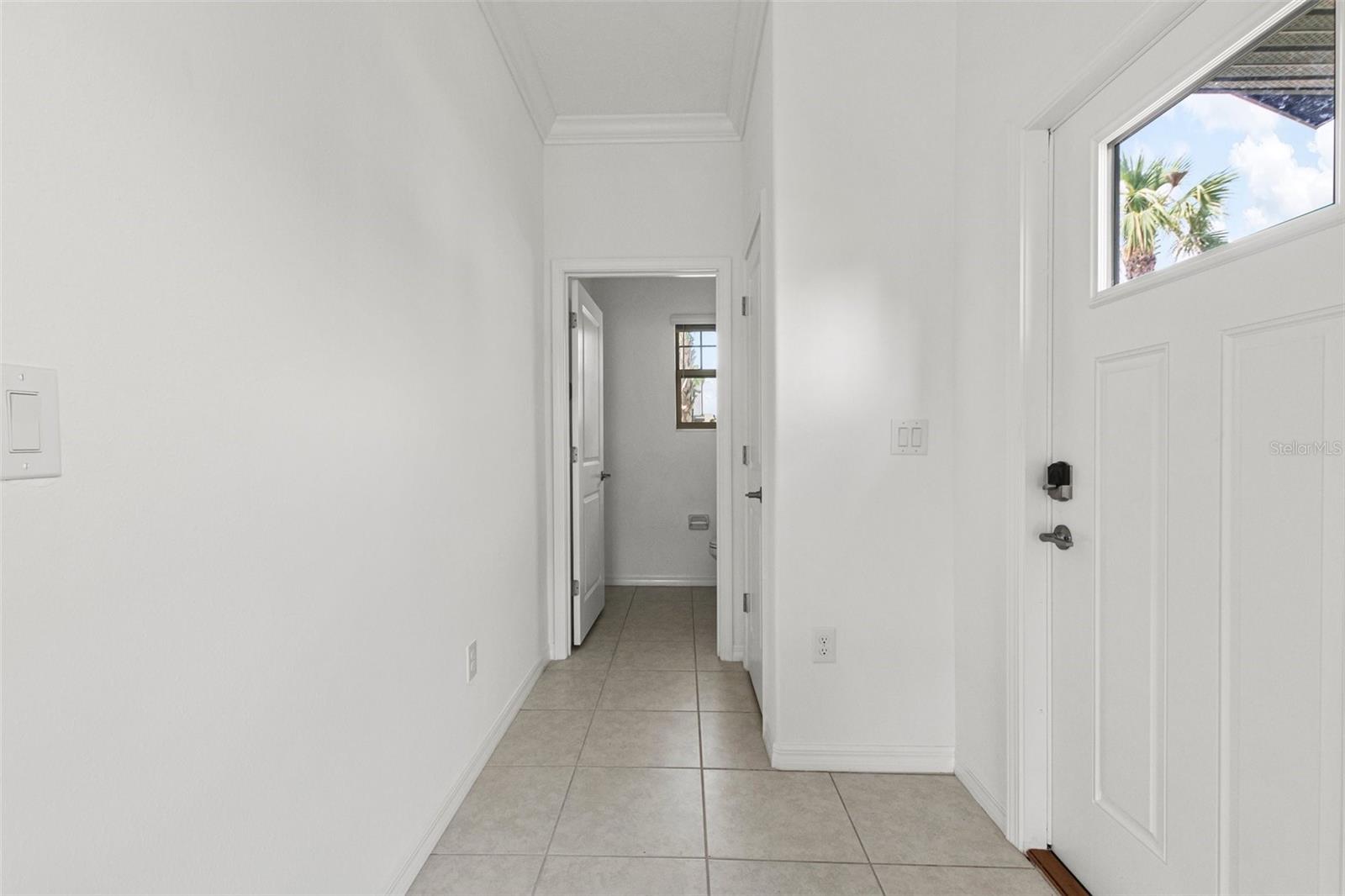 Front door and pathway to the powder room and garage