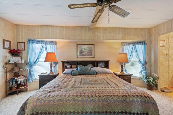 Master bedroom has ceiling fan, Berber carpeting, and walk-in closet.