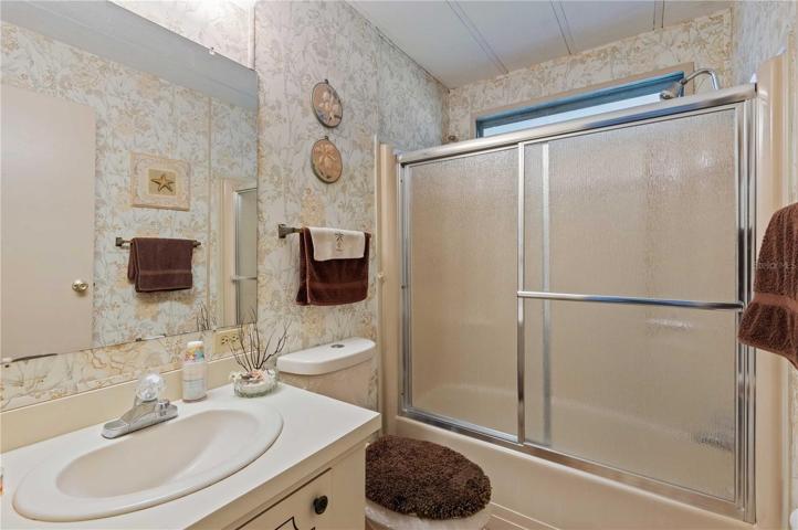 Guest bathroom has tub/shower, vanity, and high toilet.