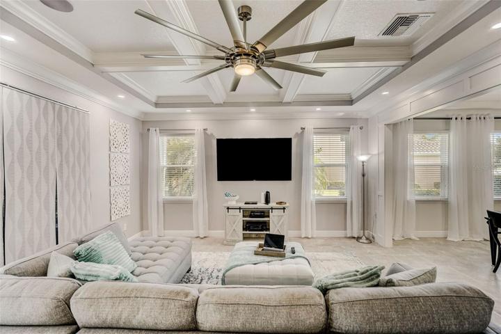 Family room with coffered ceiling and recessed lighting from kitchen