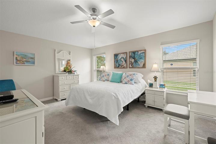 Large Primary Bedroom with high ceilings & ceiling fan with light.