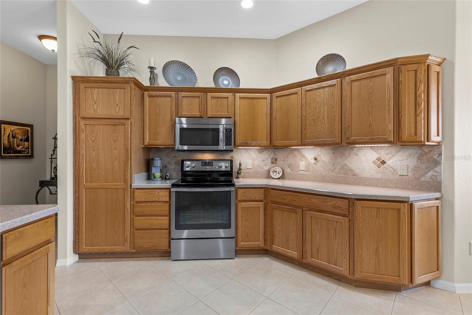 Plenty of cabinets. Backsplash and stainless steel appliances