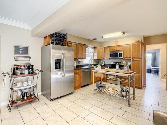 The kitchen has been remodeled with wood cabinets, stainless steel appliances and center island for additional cooking space.