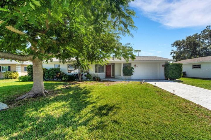 Front of home with paver driveway and beautiful shade tree