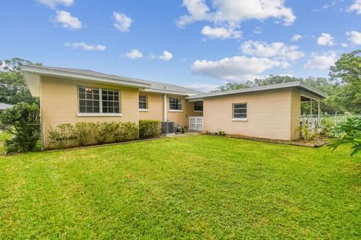 Back of home and large fenced backyard.