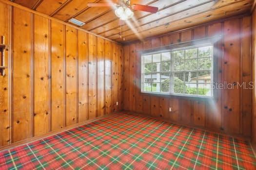 Den/Study with knotty pine ceiling and walls.
