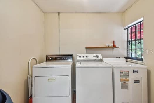 Indoor laundry room with washer and dryer included.