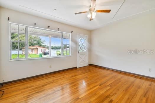Living room has beautiful hardwood floors and large picture window allowing the sunlight in.