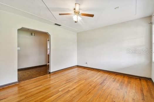 Living room opening to hallway to secondary bedrooms and kitchen.