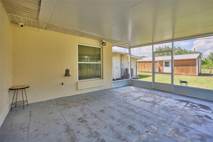 Screened patio with view of storage shed