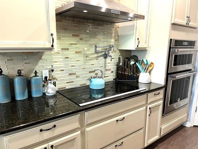 Incredible kitchen, tile back splash. Hood range, cooktop stove, and double oven.