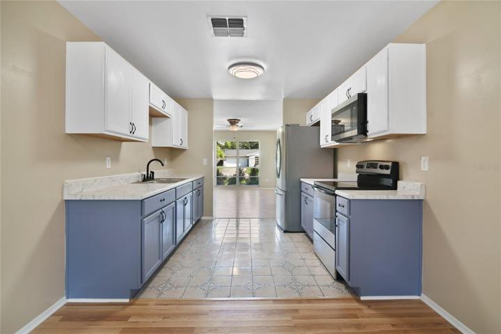 The lovely galley style kitchen sits in the heart of the home between your living and dining areas with chic two tone cabinetry, NEW STAINLESS STEEL APPLIANCES and plenty of storage for easy meal prep!