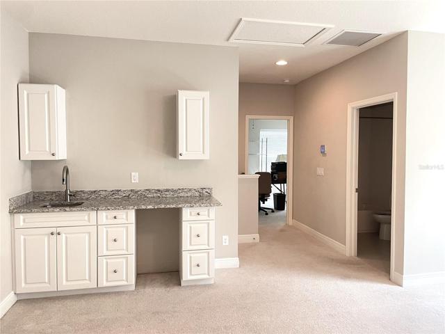 sink with cabinets and place for mini fridge
